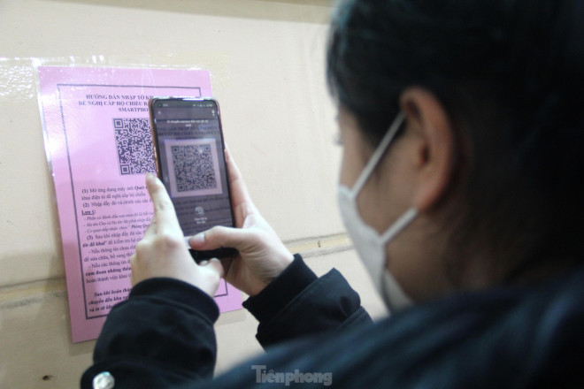 Các công dân dùng điện thoại thông minh được hướng dẫn quét mã QR, đăng nhập nội dung tờ khai điện tử trong thời gian chờ vào trụ sở làm hồ sơ.