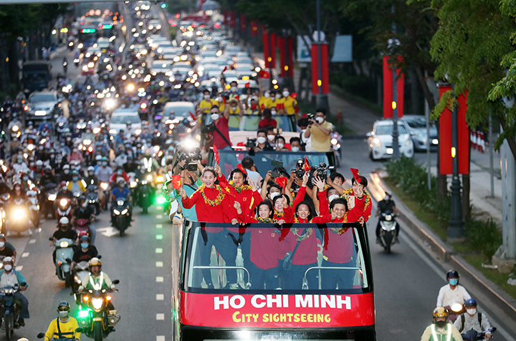 Huỳnh Như và đồng đội rạng rỡ vẫy tay
chào người hâm mộ trên đường diễu hành về làm lễ mừng công ở UBND
TP.HCM