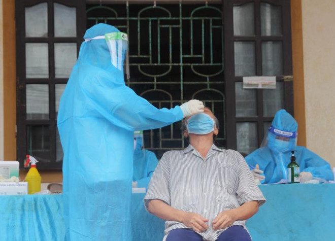 Lực lượng chức năng Nghệ An lấy mẫu test nhanh cho người dân.