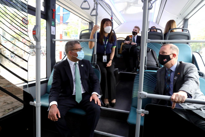 Bộ trưởng Chính phủ Anh, Chủ tịch COP26, Alok Kumar Sharma (bìa trái ảnh) và Đại sứ Anh tại Việt Nam Gareth Ward trên xe buýt điện
