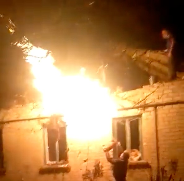 Pháo kích đốt cháy một ngôi nhà ở miền đông Ukraine (ảnh: TASS)