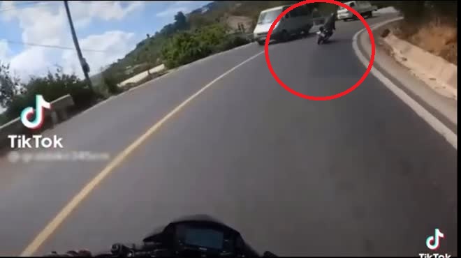 Một lái xe máy chạy trước xe máy gặp nạn nghiêng người ôm cua.
