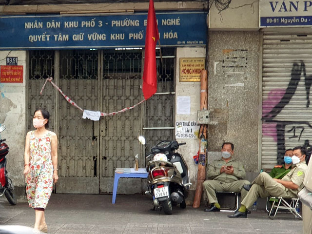 Lực lượng chức năng túc trực trước cửa ra vào chung cư 89-91 Nguyễn Du