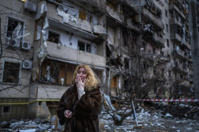 Một người phụ nữ Ukraine bên ngoài căn nhà bị tên lửa Nga tấn công ở thủ đô Kiev. Ảnh: AP