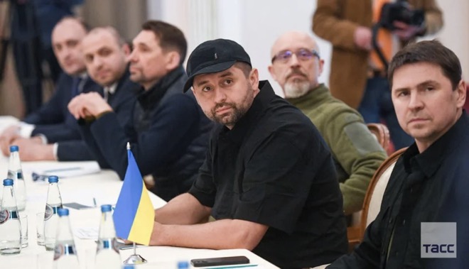 Người đàn ông đội mũ lưỡi trai ngồi giữa bàn đàm phán bên phía Ukraine là&nbsp;Davyd Arakhamia,&nbsp;lãnh đạo đảng Người phụng sự nhân dân,