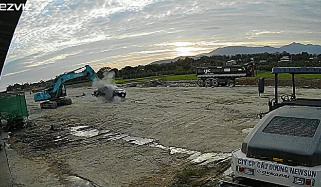 Hoàng dùng gàu múc đập vào đầu xe ô tô có thủ kho ngồi bên trong.