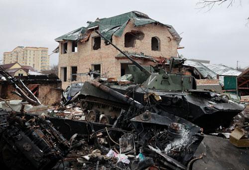 Một thiết giáp, chưa rõ của phe nào, bị phá hủy trên đường phố của thành phố Bucha thuộc vùng Kiev ngày 1-3 Ảnh: REUTERS