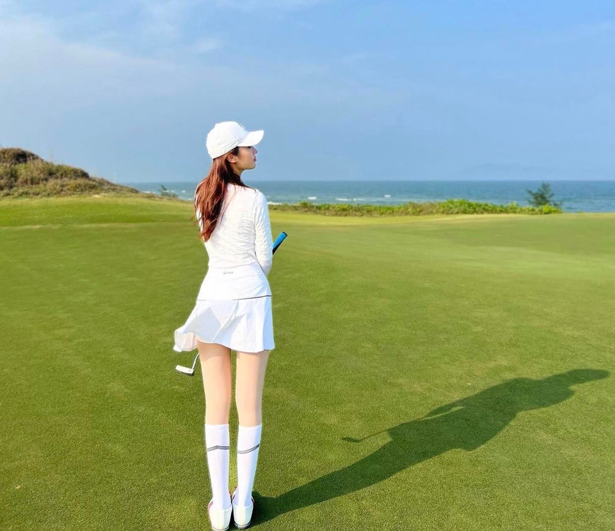 Đỗ Mỹ Linh ghi điểm với set đồ trắng thanh lịch trên sân golf nhưng chiếc váy xếp ly ngắn, mỏng&nbsp;dễ khiến người đẹp "rước họa vào thân" nhất là khi có cơn gió thổi qua.