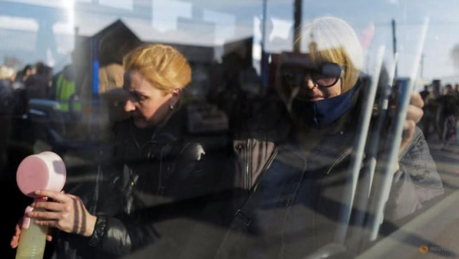Những phụ nữ chạy Ukraine ngồi trong chiếc xe buýt sau khi vượt biên từ Ukraine sang Ba Lan tại trạm kiểm soát biên giới ở Medyka, ngày 15-3. Ảnh: REUTERS