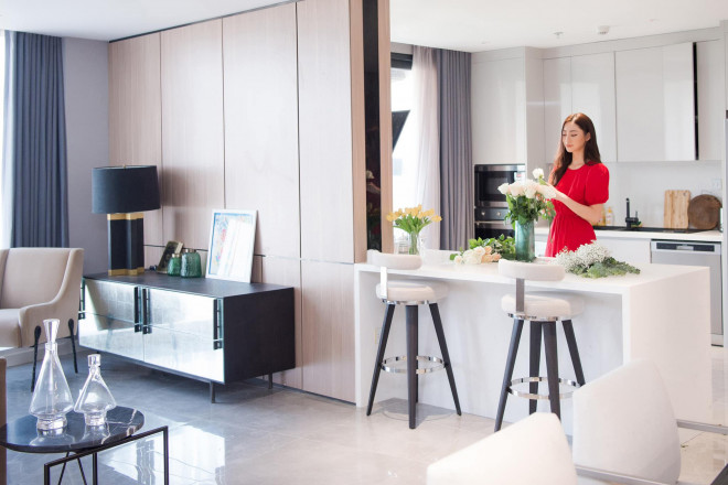 Phòng bếp nối liền với phòng khách để tận dụng tối đa không gian và có màu trắng chủ đạo. Căn bếp có bàn đảo đồng thời là bàn ăn