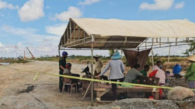 Lực lượng chức năng làm việc với nhóm người dân che lều chắn đường dẫn vào công trình điện gió trên địa bàn thị xã Vĩnh Châu.