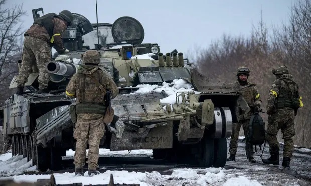 Binh sĩ Ukraine kiểm tra một xe tăng bị quân đội Nga bỏ lại.