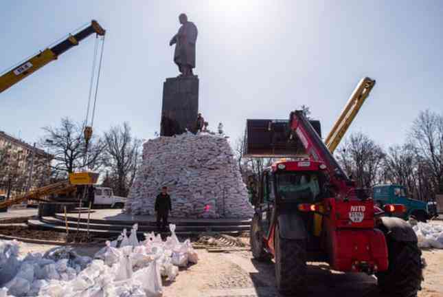 Các nhân viên đắp bao cát xung quanh tượng đài Taras Shevchenko ở Kharkiv để tránh hư hại trước bom đạn. (Ảnh: Guardian)