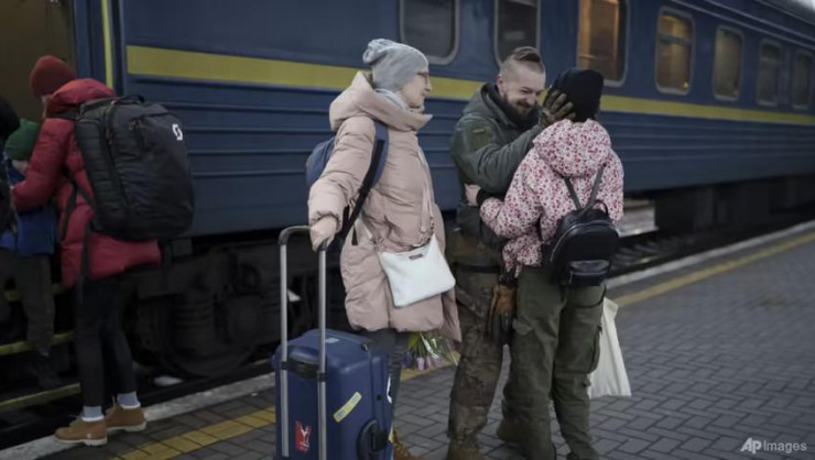 Anh Vasyl Khomko - một quân nhân Ukraine - đón vợ và con gái về Kiev đoàn tụ dịp năm mới sau nhiều tháng xa cách. Ảnh: AP