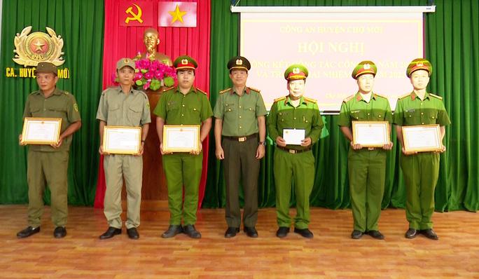 Đại tá Nguyễn Nhật Trường (giữa), trao giấy khen của Giám đốc Công an tỉnh An Giang cho 5 cá nhân và trao thưởng "nóng" 5 triệu đồng cho tập thể Công an huyện Chợ Mới