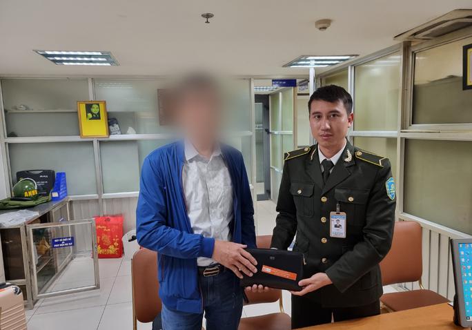 Anh Nguyễn Như Dương - Nhân viên An ninh sân đỗ ô tô - Trung tâm An ninh hàng không Nội Bài - trao trả lại tài sản thất lạc cho hành khách. Ảnh: NIA