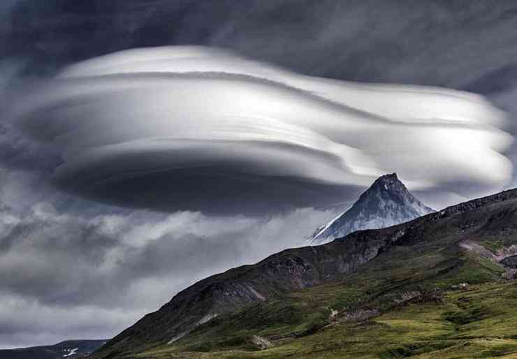 Núi lửa Tolbachik, Nga: Theo Lonely Planet, đi bộ qua thung lũng phủ đầy tro&nbsp;giữa các ngọn núi lửa Tolbachik, bạn sẽ phát hiện loạt UFO khổng lồ lơ lửng trong không trung. Thực tế, vật thể trông giống UFO này là những đám mây dạng thấu kính có hình dạng giống như chiếc đĩa. Thường bị nhầm là UFO, những đám mây này chỉ xuất hiện trong một số điều kiện thời tiết nhất định khi nhiệt độ đủ thấp và độ ẩm trong không khí có lợi cho chúng. Ảnh: Guardian.