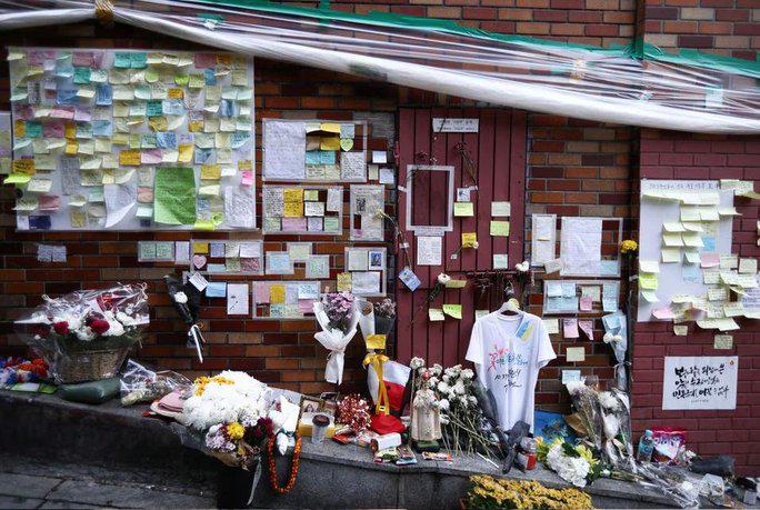 Thân nhân những nạn nhân trong thảm kịch Itaewon đặt hoa và các đồ vật tưởng niệm tại con hẻm nơi xảy ra vụ giẫm đạp khiến 159 người thiệt mạng và nhiều người khác bị thương - Ảnh: REUTERS