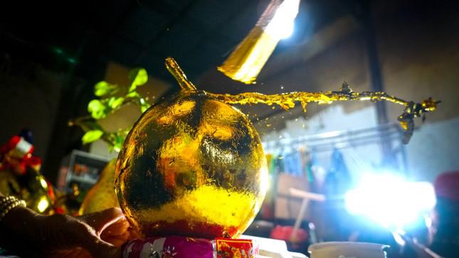 Dùng cọ phủ lá vàng dư để tạo độ bóng đẹp cho trái dừa.