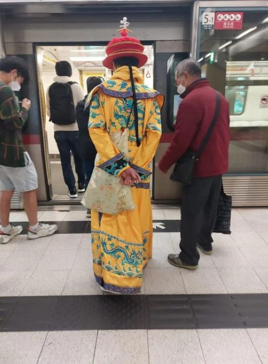 Nam hành khách đi tàu điện ngầm MTR trong trang phục Hoàng đế Trung Quốc thời nhà Thanh.