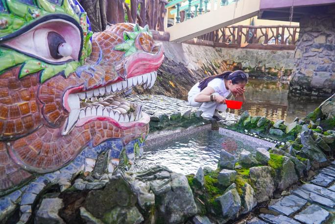 Nước từ lòng đất phun lên sẽ chảy thẳng vào hồ chứa để khách thập phương dễ dàng lấy nước hơn.