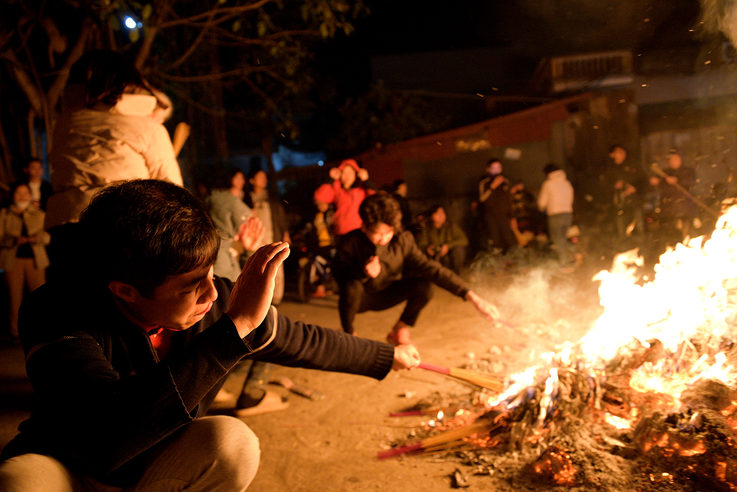  Hơi nóng hầm hập toả ra từ đống lửa khiến việc châm hương rất khó khăn
