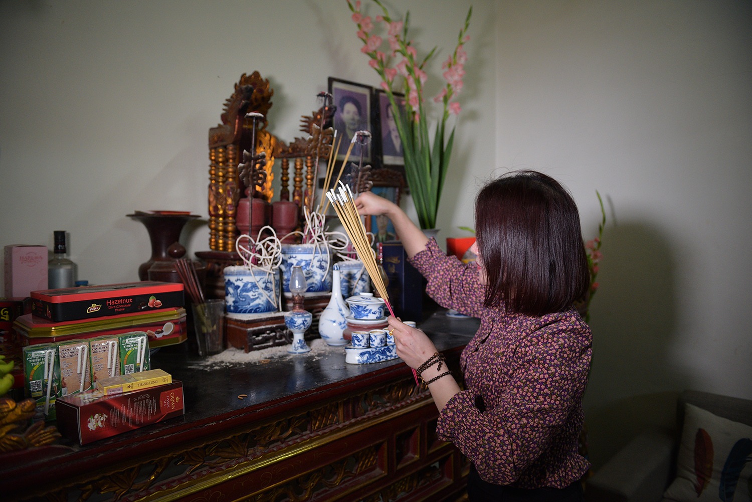  Chị Trang mang những nén hương từ đình về ban thờ gia tiên nhà mình, cầu mong một năm nhiều tài lộc, nhiều may mắn.