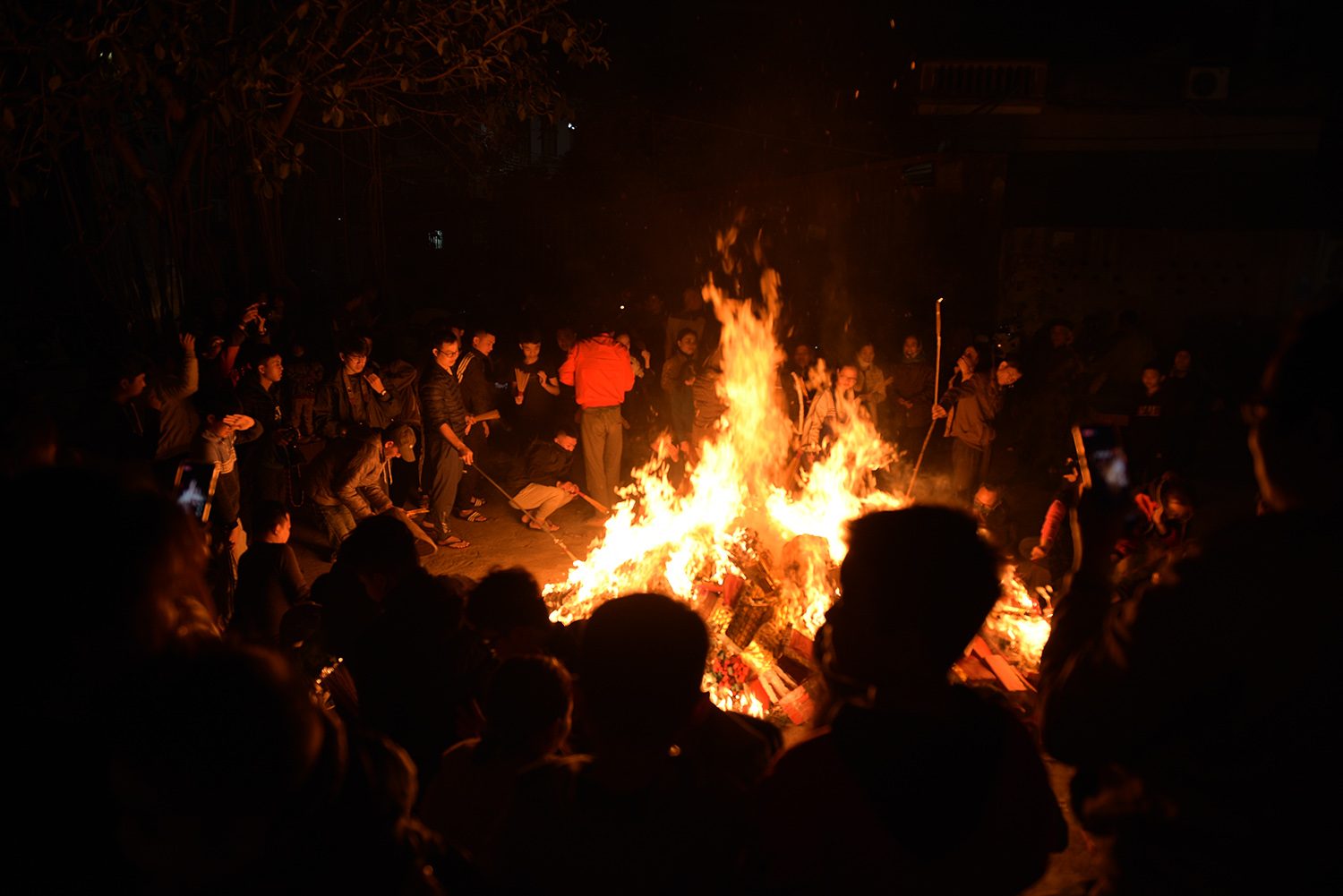 Ngọn lửa bùng lên dữ dội giữa sân đình, xung quanh hàng trăm người châm hương vào lấy lửa