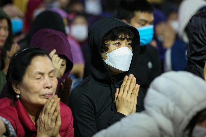 Càng về tối càng chuyển lạnh hơn, lác đác kèm mưa phùn nhỏ nên nhiều người phải trùm kín áo để nghe sư thầy tụng kinh.