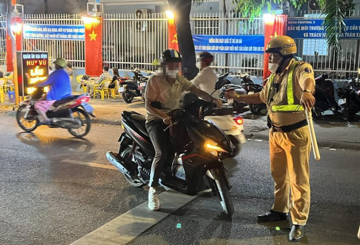 CSGT kiểm tra với một người đàn ông vào tối 3-2. Ảnh: NY