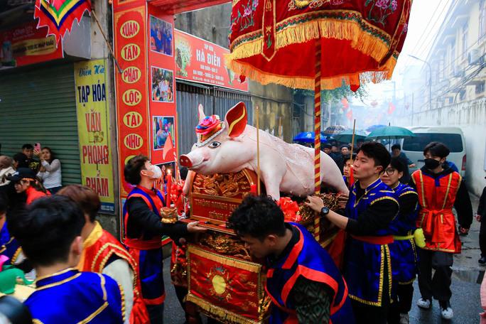Đúng 17 giờ chiều ngày 3-2, các “ông lợn” và lễ vật được người dân rước qua các ngõ, đường làng với tiếng trống rộn ràng, linh đình.