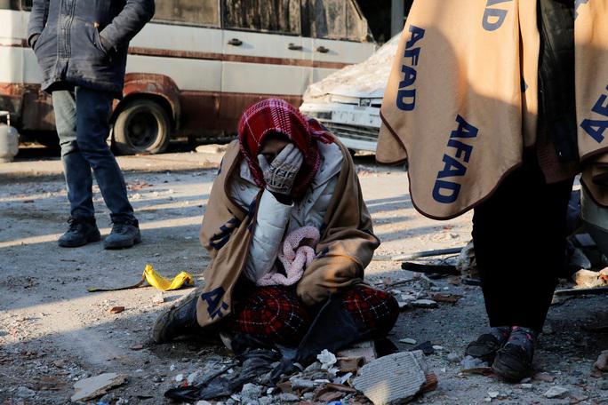 Một phụ nữ ôm mặt khóc bên cạnh một tòa nhà bị sập ở Kahramanmaras - Thổ Nhĩ Kỳ hôm 8-2 - Ảnh: REUTERS