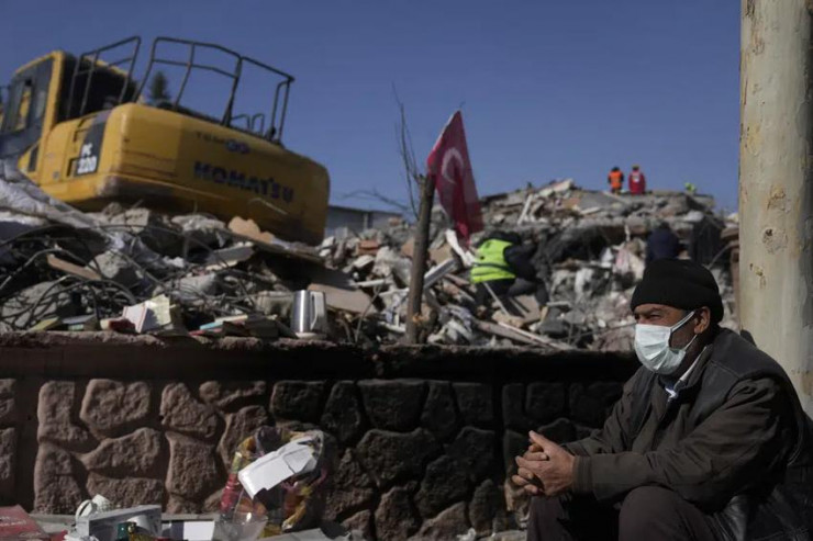Một người đàn ông ngồi cạnh đống đổ nát của các tòa nhà bị phá hủy ở Adiyaman, miền nam Thổ Nhĩ Kỳ ngày 12-2. Ảnh: AP