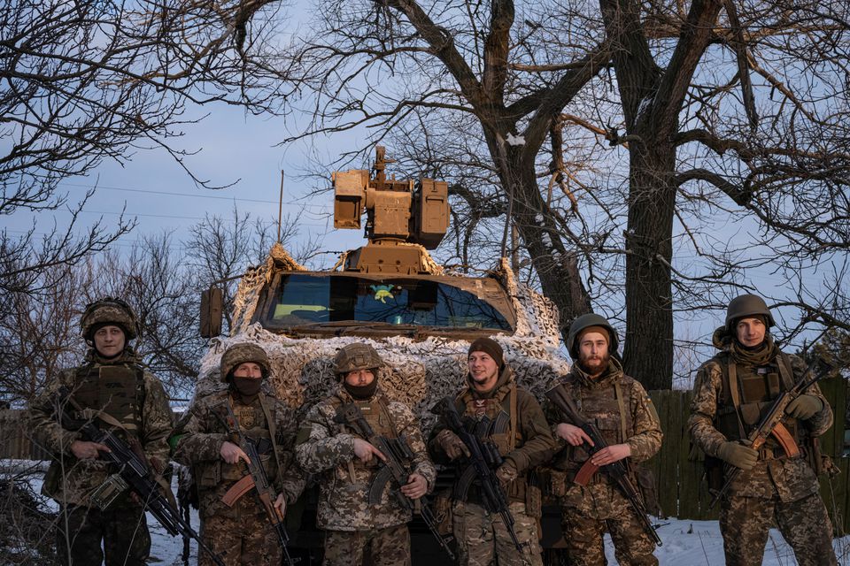Các binh sĩ Ukraine tham gia phòng thủ Bakhmut đứng phía trước xe bọc thép Bushmaster do Úc cung cấp.