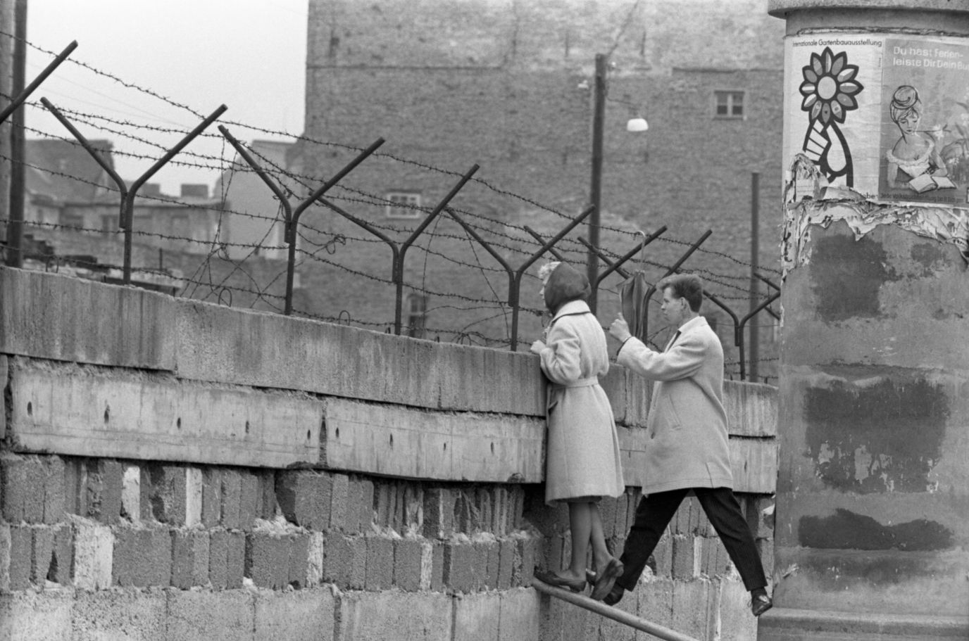 Một phụ nữ cùng bạn trai nhìn qua phía bên kia của Bức tường Berlin - một trong những biểu tượng nổi tiếng nhất của Chiến tranh Lạnh - năm 1962. Ảnh: Getty