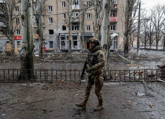 Một người lính Ukraine đứng giữa quang cảnh đổ nát của TP Bakhmut hôm 25-2 - Ảnh: REUTERS