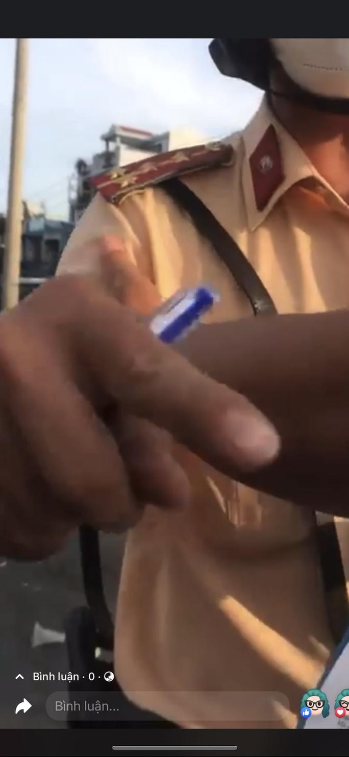 CSGT và người bị lập biên bản vi phạm lời qua tiếng lại. Ảnh cắt từ clip.