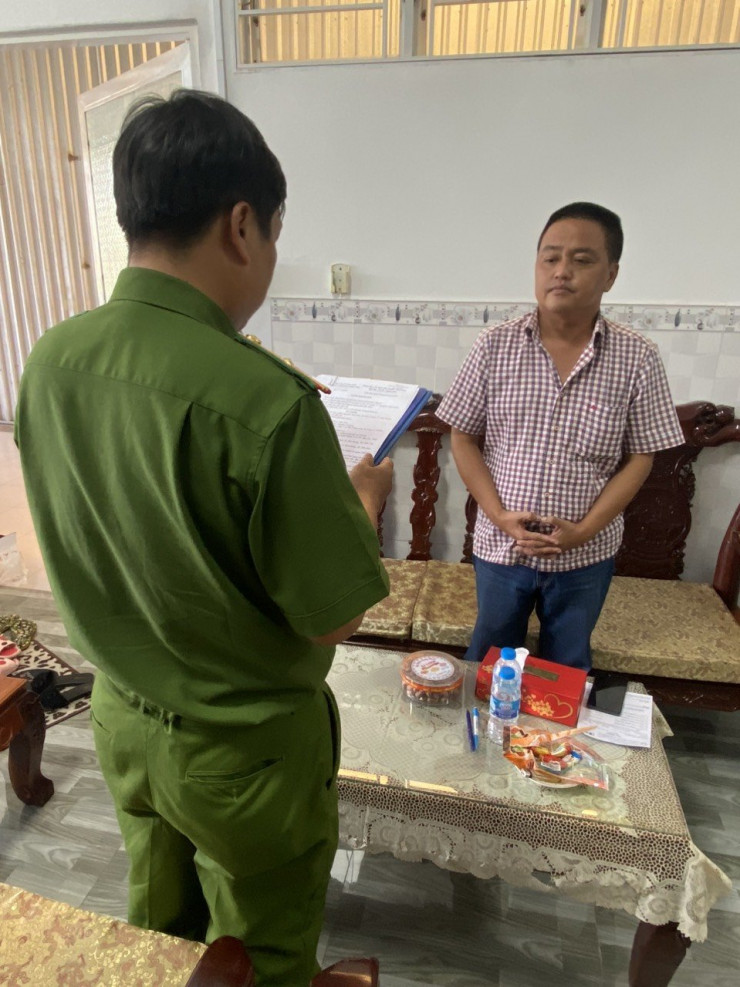 Cán bộ điều tra tống đạt quyết định khởi tố bị can, bắt tạm giam Nguyễn Sỹ Hùng. Ảnh: Công an Cần Thơ