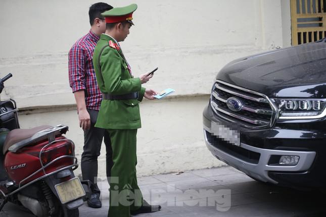 Lực lượng chức năng phường Trần Hưng Đạo kiểm tra, chụp lại giấy tờ xe trước khi yêu cầu phương tiện này di chuyển. Ảnh: Trường Phong