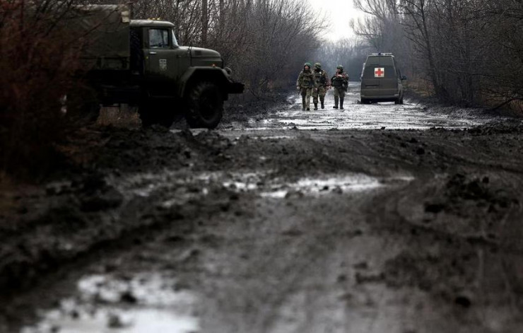 Quân nhân Ukraine đi dọc con đường lầy lội gần TP Bakhmut ngày 8-3. Ảnh: REUTERS