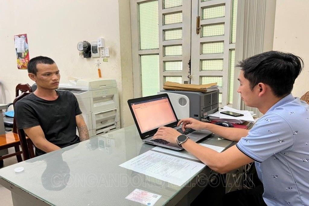 Ảnh đối tượng Hoàng Việt Tới (áo đen) đang làm việc với Cơ quan điều tra (ảnh: Công an Đồng Nai)
