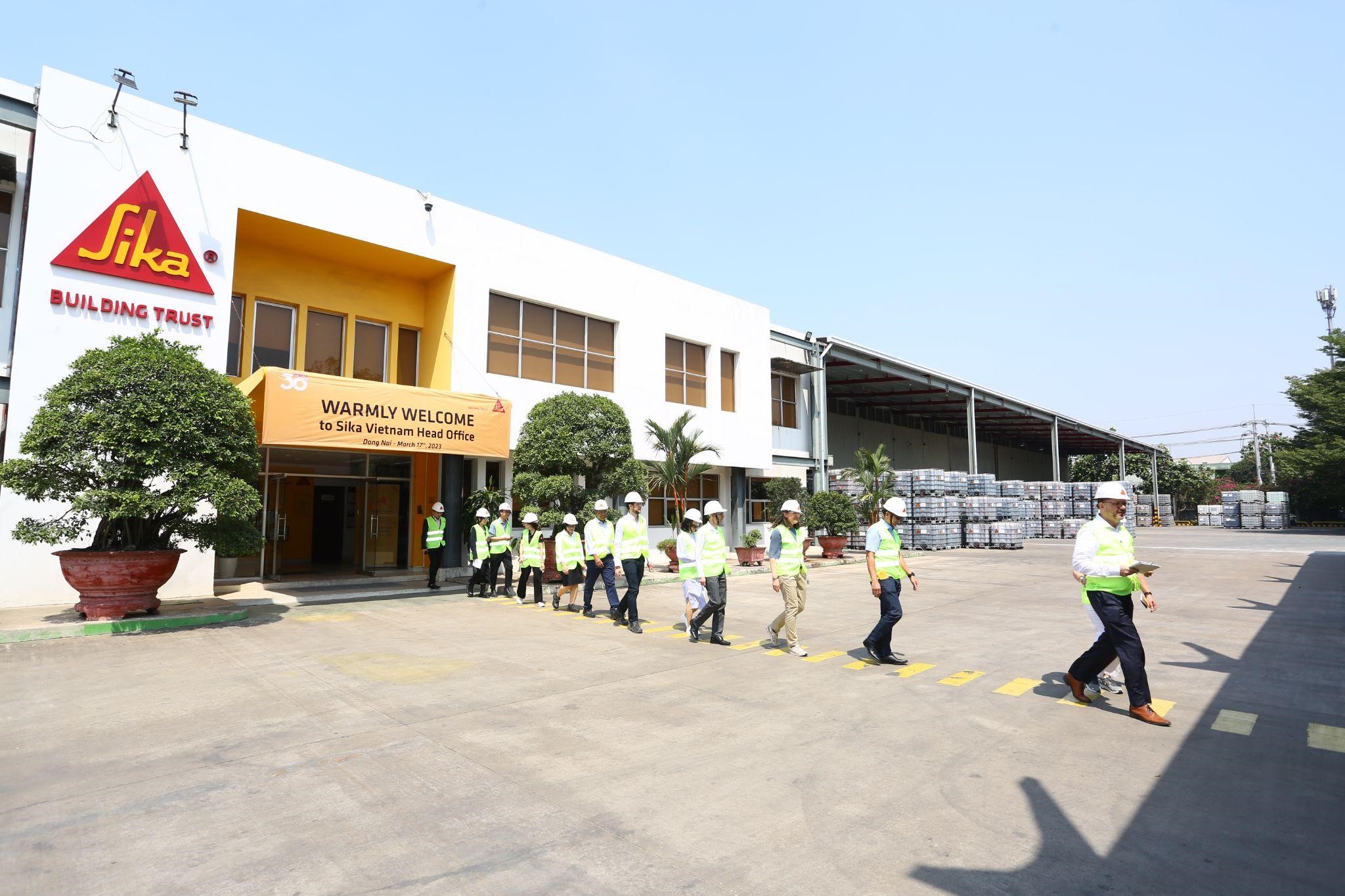 Đoàn đại biểu đang tiến vào khu vực sản xuất và kho bãi của nhà máy