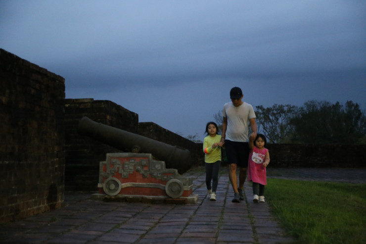 Những em nhỏ cùng người lớn dạo bộ trên thượng thành.