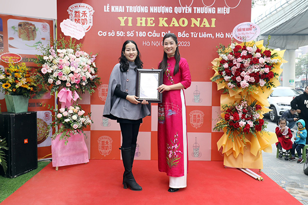 Chị Thanh Nhàn chủ chuỗi thương hiệu Trà Sữa Nướng Yi He Kao Nai Việt Nam trao chứng nhận cửa hàng nhượng quyền Yi He Kao Nai 180 Cầu Diễn