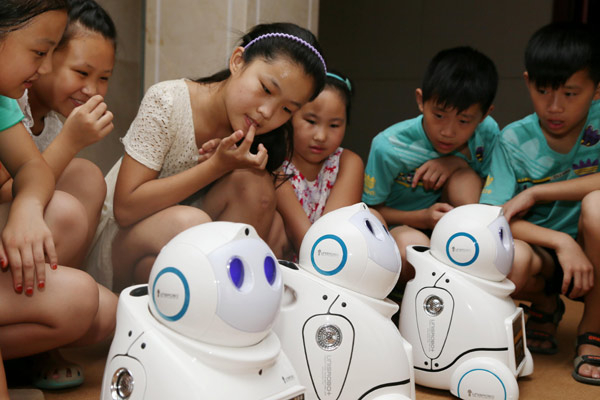 Các học sinh tiểu học quan sát robot thông minh có khả năng hỗ trợ giảng dạy và làm việc nhà.