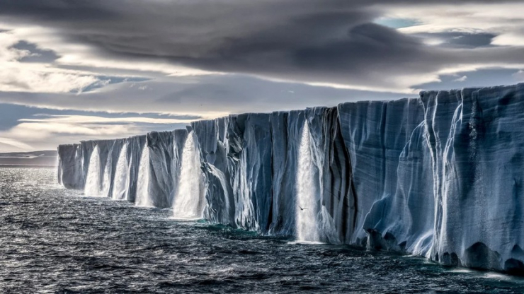 Thác nước đổ xuống từ chỏm băng trên đảo Nordaustlandet, Na Uy, trong mùa hè ấm áp bất thường năm 2014. Các sông băng trên Trái Đất đang tan chảy với tốc độ chưa từng thấy do biến đổi khí hậu. Ảnh: PAUL NICKLEN
