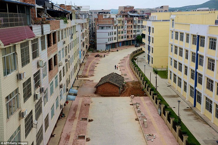 Một ngôi nhà nằm ngay giữa đường đang xây ở một khu tự trị tại Nam Ninh, Quảng Tây, Trung Quốc.  Lý do khiến ngôi nhà vẫn chưa chịu di dời là vì chủ nhà cảm thấy tiền đền bù không thỏa đáng.
