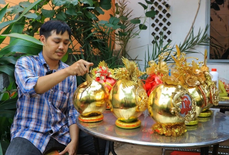 Gần Tết Nguyên đán Giáp Thìn 2024, vợ chồng anh Nguyễn Anh Vũ (ngụ TP Thủ Đức, TP HCM) lại tất bật sản xuất những quả dừa dát vàng phục vụ nhu cầu trưng bày dịp Tết của khách hàng. Ảnh: Plo