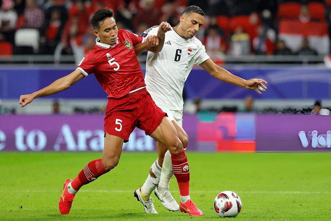 Indonesia (áo đỏ) thất bại trước Iraq ở trận mở màn Asian Cup 2023. (Ảnh: KARIM JAAFAR/Getty)