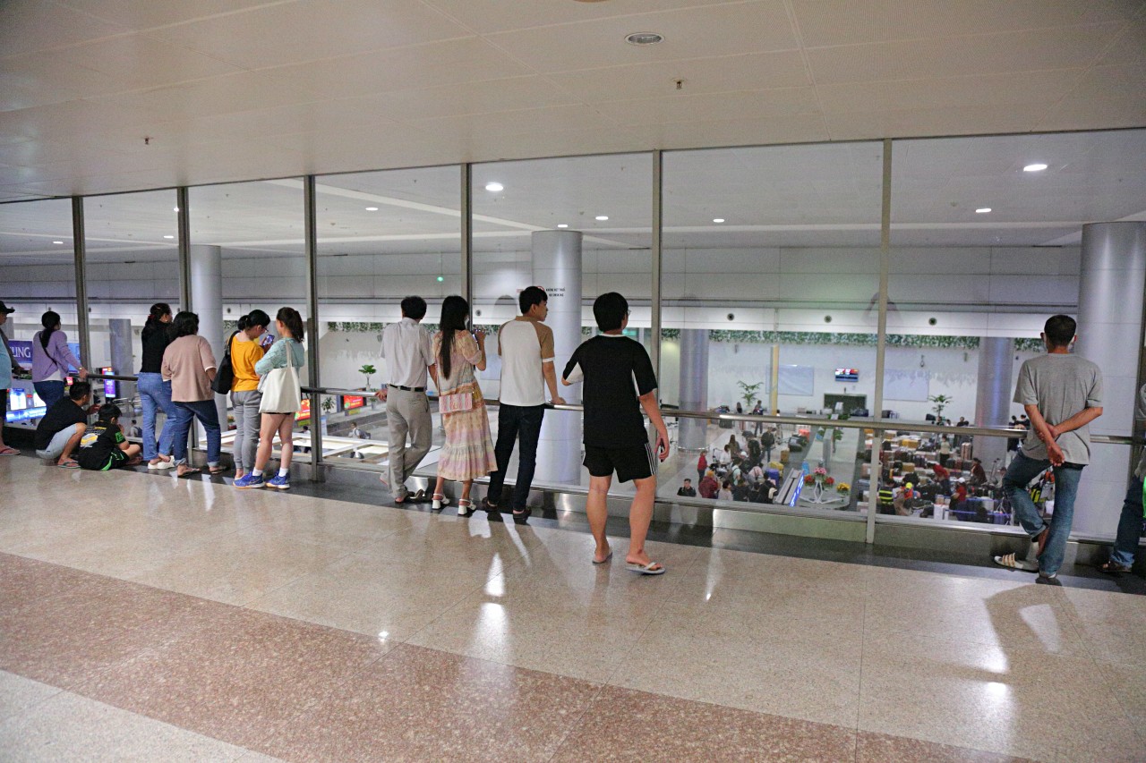 Không chỉ khu vực sảnh tầng trệt, khu vực tầng 1 của ga quốc tế cũng có nhiều người dân đứng dõi theo người thân Việt kiều đang chờ lấy hành lý tại băng chuyền.